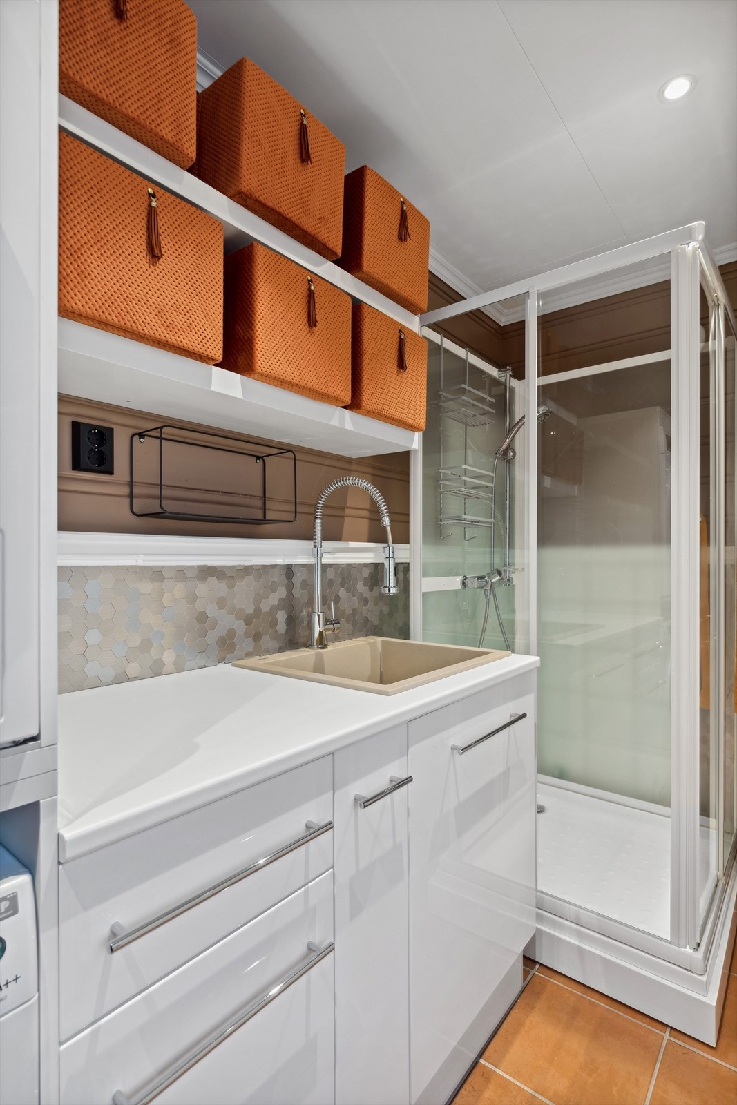 Praktisk utformet med baderomsløsninger og er utstyrt med innredning med servant, dusjkabinett, toalett, varmtvannsbereder og opplegg for vaskemaskin. Galleribilde