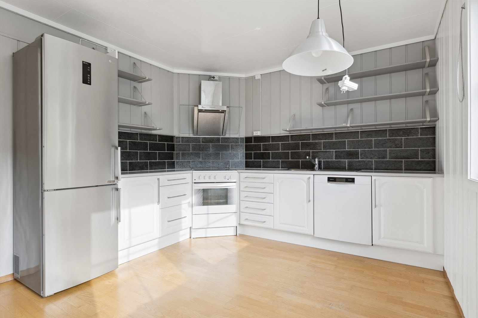 Pent kjøkken med rikelig med skap- og benkeplass. Galleribilde