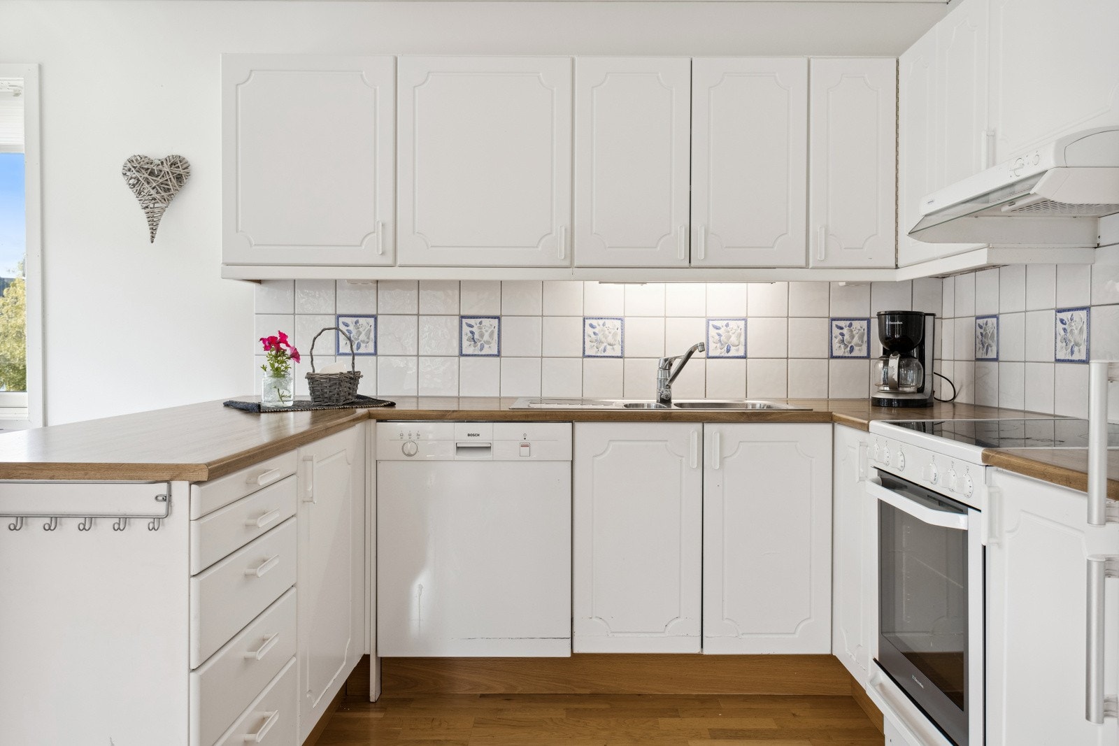 Tidløst kjøkken med lyse fronter og rikelig med skap- og benkplass. Galleribilde