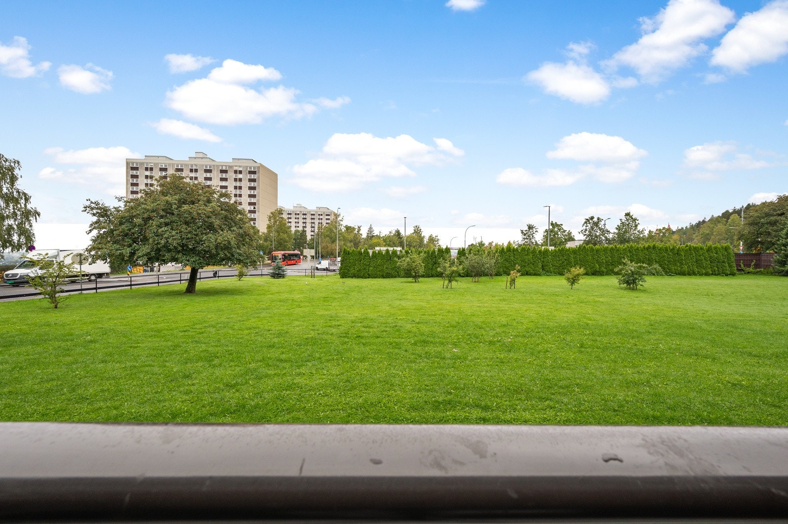 Utsikt fra balkongen ut mot flott, felles hage. Galleribilde