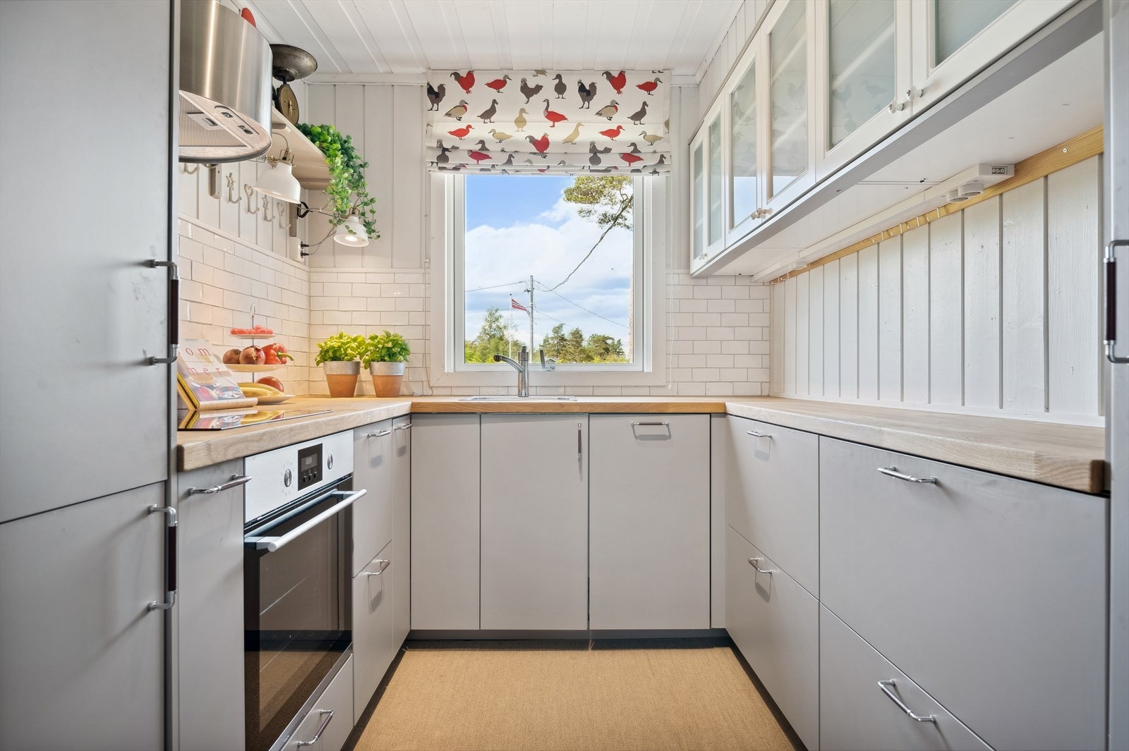 IKEA kjøkkeninnredning fra 2017 med glatte fronter, heltre benkeplate og delvis flislagte vegger. Galleribilde