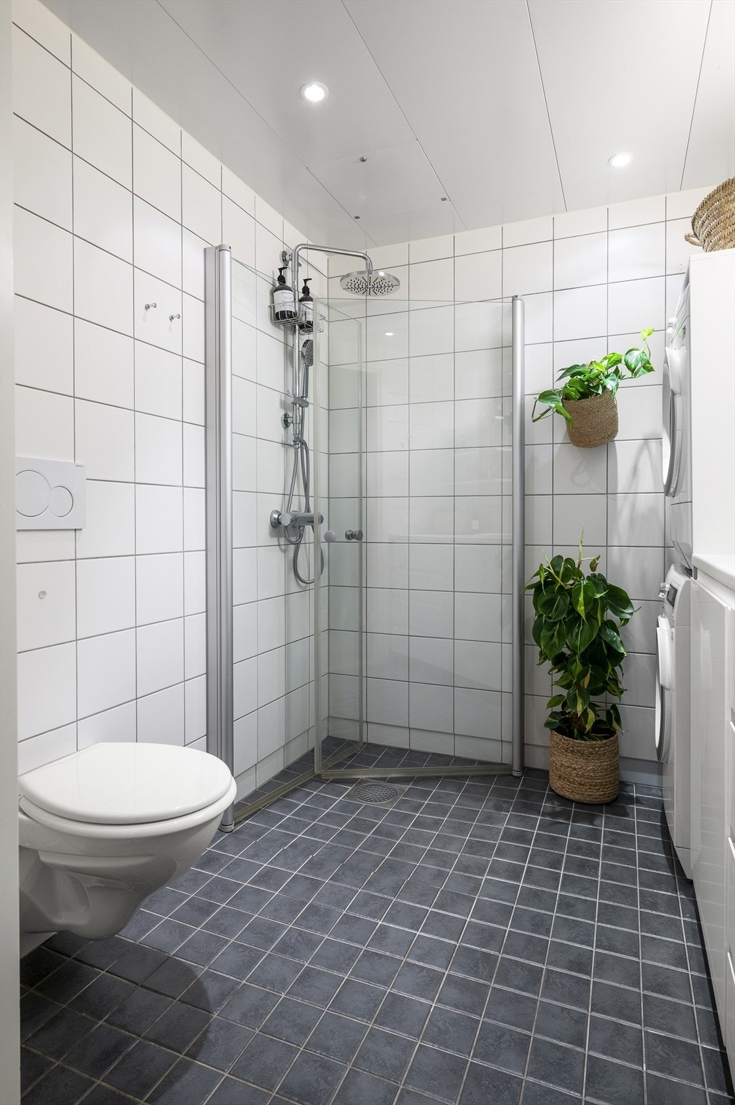 Badet er utstyrt med vegghengt toalett og dusjhjørne med innfellbare glassdører i herdet glass og rainshower Galleribilde
