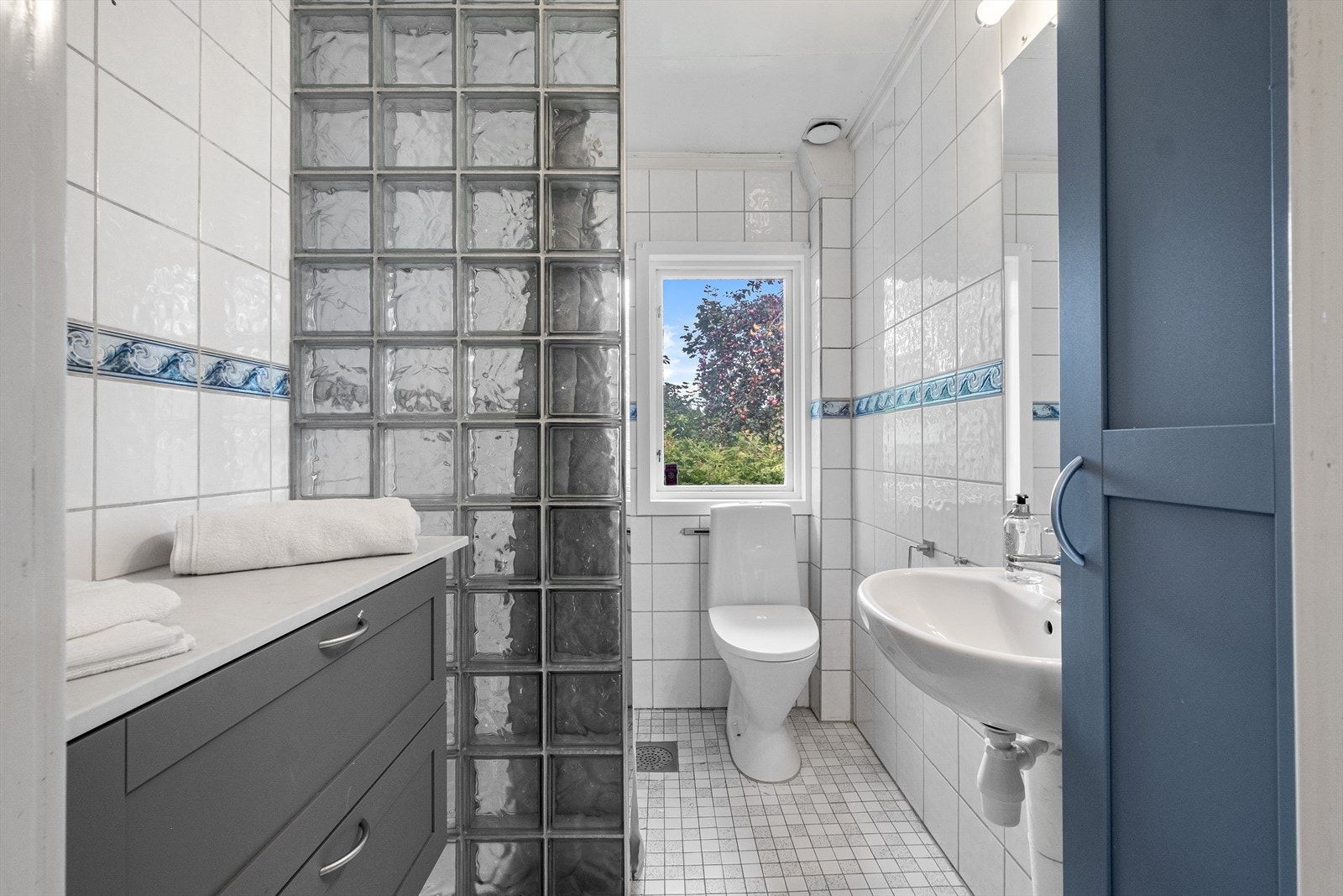 Pent og flislagt baderom, av eldre dato. Det er noe nyere innredning og wc i rommet. Galleribilde