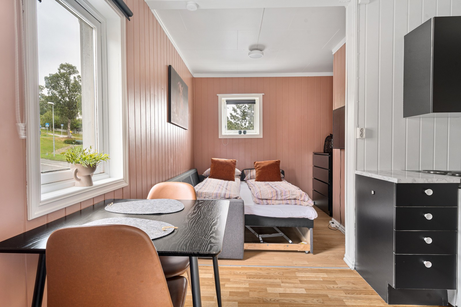 Rom med egen inngang har plass for sovesofa, tv og spisebord.