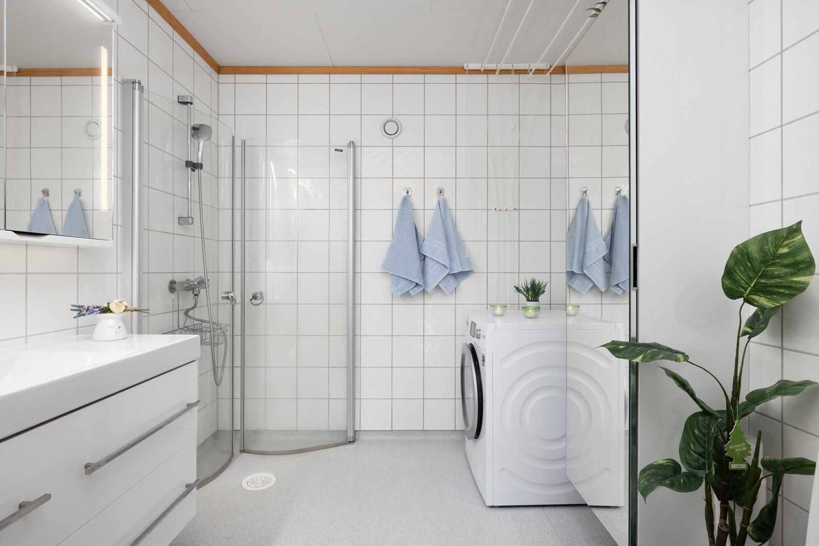 Badet er innredet med servant på innredning, dusjhjørne med glassdører og toalett. Galleribilde