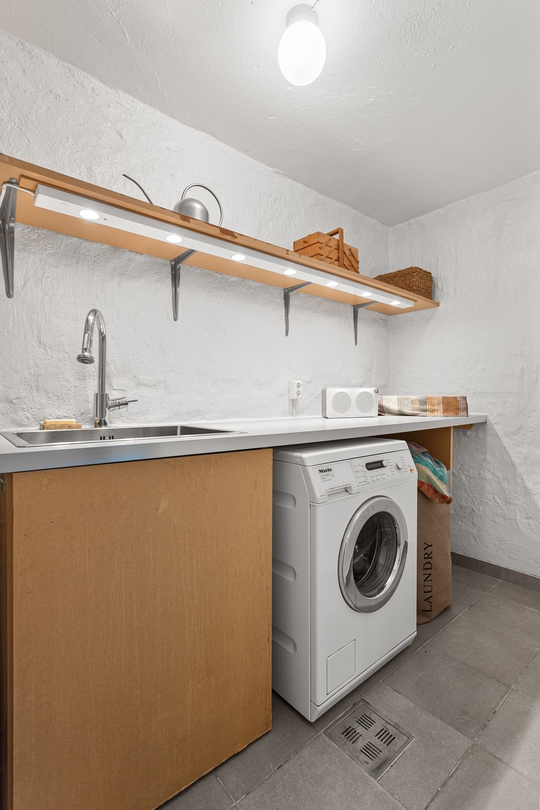 Eget vaskerom med plass til vaskemaskin, tørketrommel, vask, bereder, vaskeutstyr og oppbevaring. Galleribilde