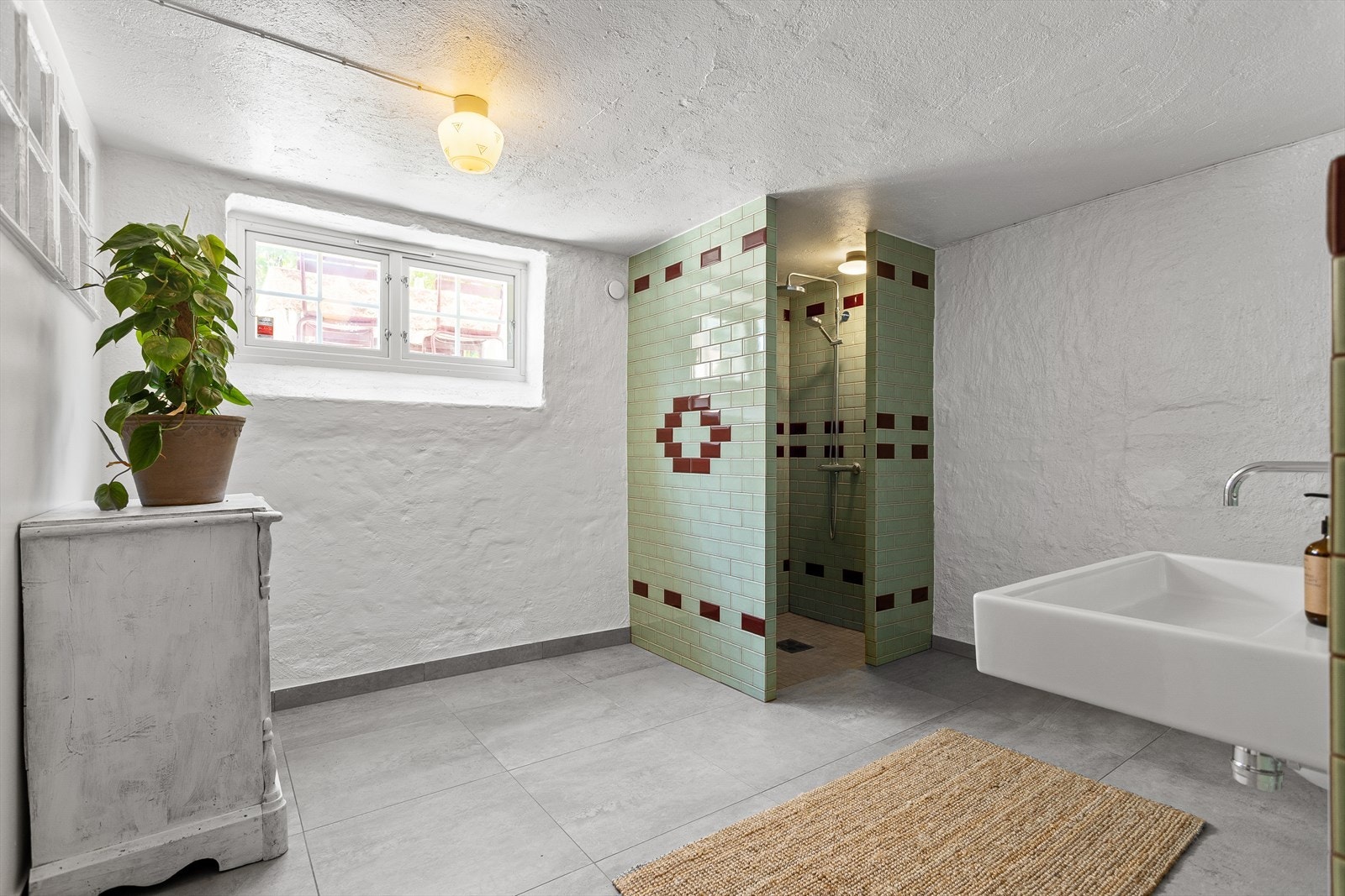 Badet er utstyrt med vegghengt wc, servant og dusj i hjørnet. Galleribilde