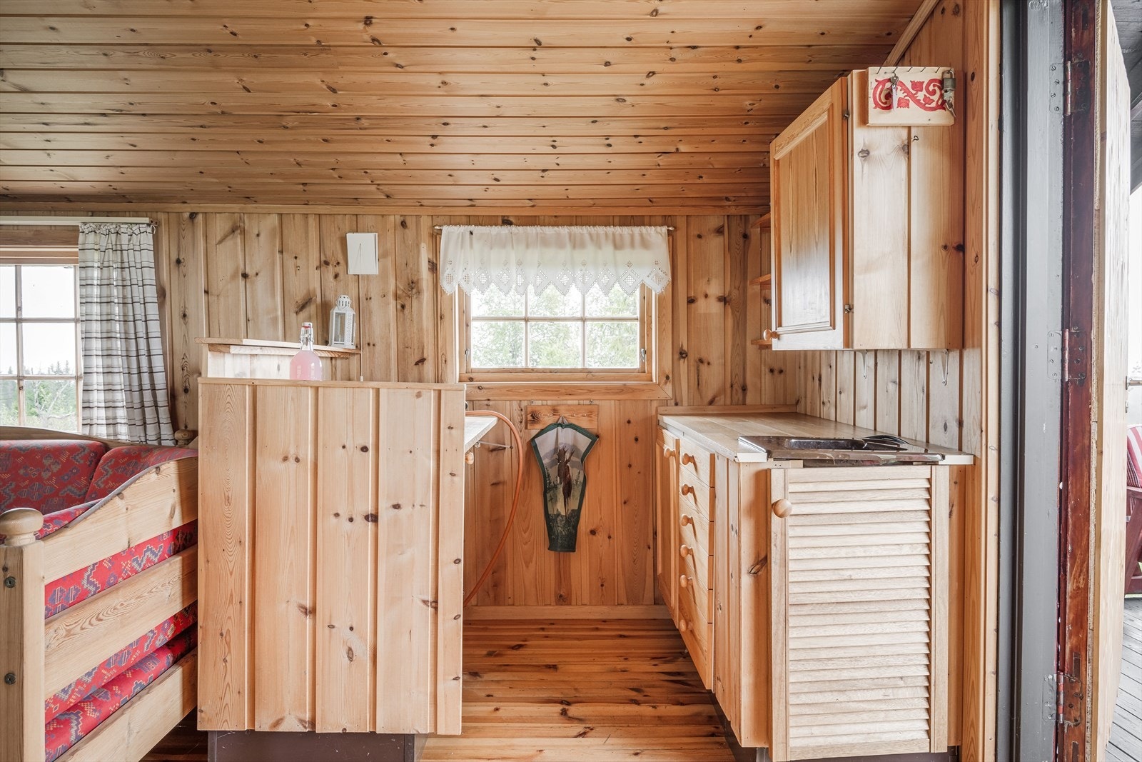 Velholdt hyttestandard med lakkerte tregulv og overflater med panel. Galleribilde