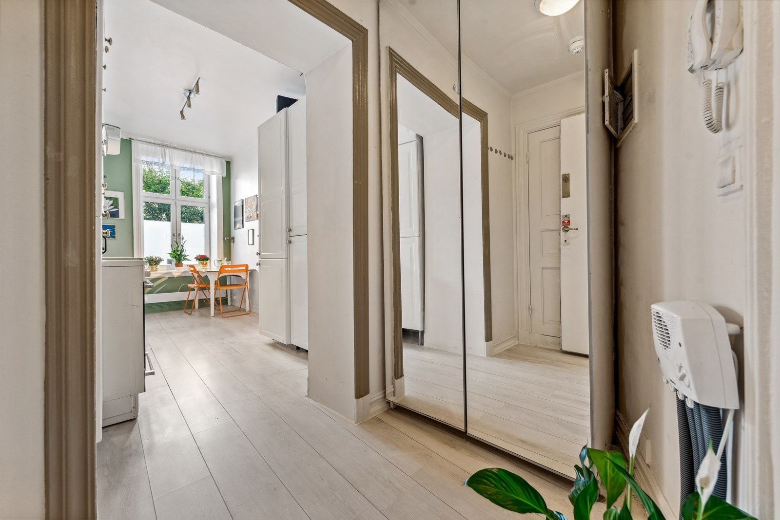 Stor og lys entré med plass til å henge fra seg i garderobeskap med speilfronter Galleribilde