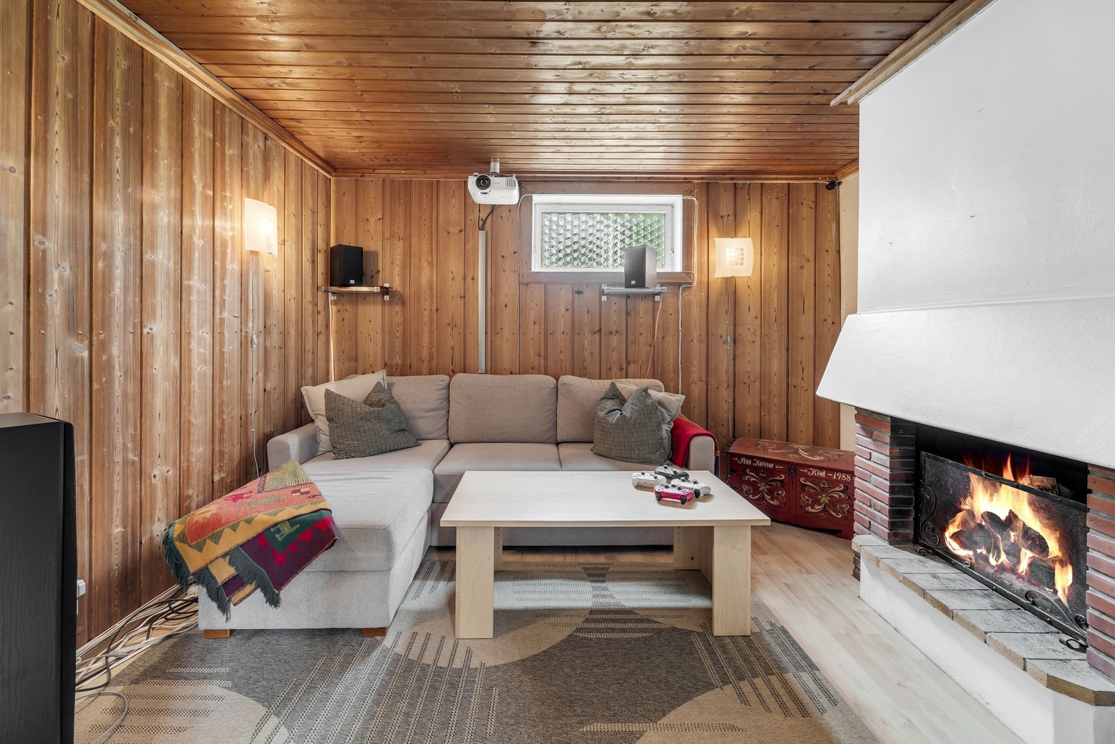 Boligen har en lun, tradisjonell peisestue med panelvegger, paneltak og laminatgulv. Det er plassmurt peis med teglstein, hvit hette og åpent ildsted. Rommet byr på ekstra privatliv, og er et koselig sted man kan invitere venner på besøk. Galleribilde