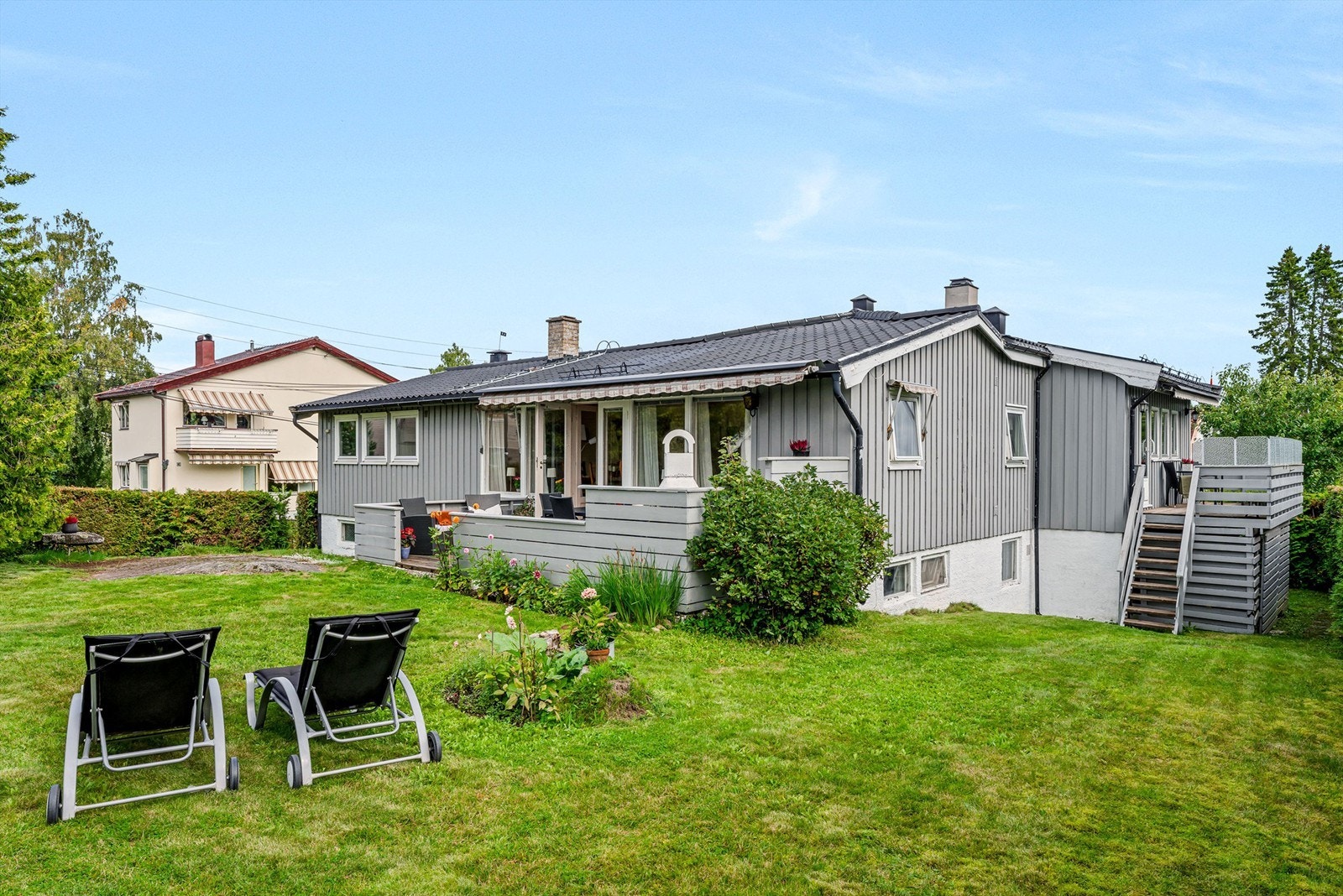 Stor hage opparbeidet med plen og beplantning. Galleribilde