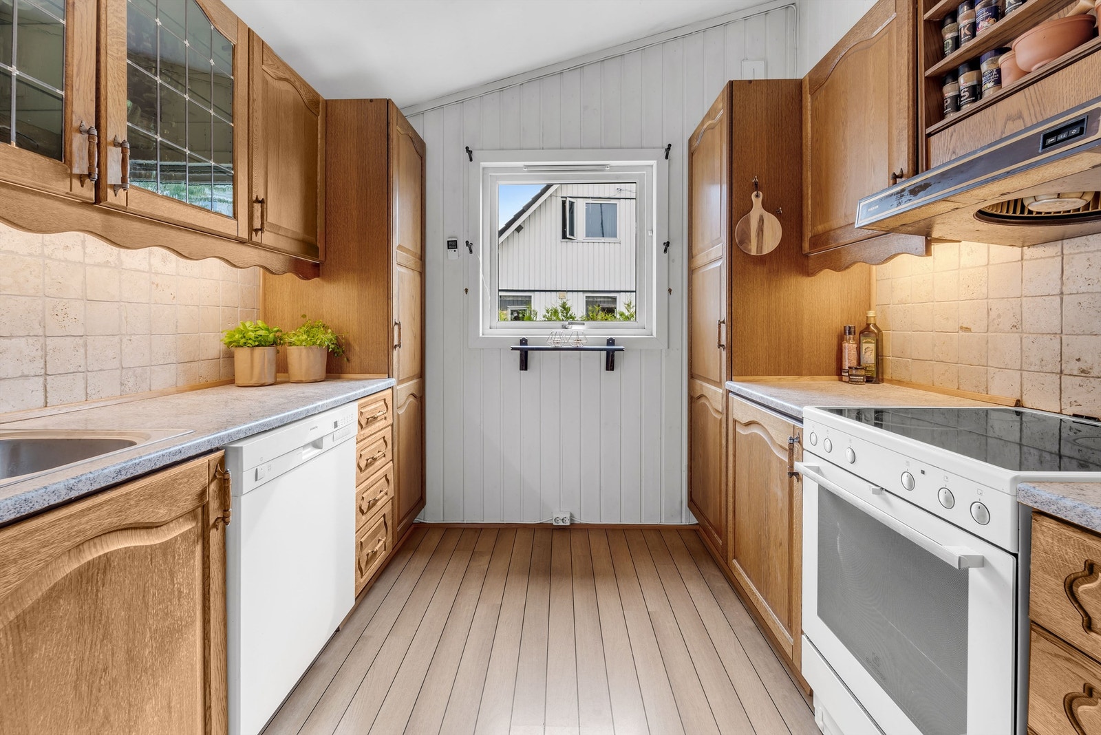 Innredningen er montert langs to parallelle vegger og har profilerte trefronter, overskap med blyglass og benkeplater i laminat. Galleribilde