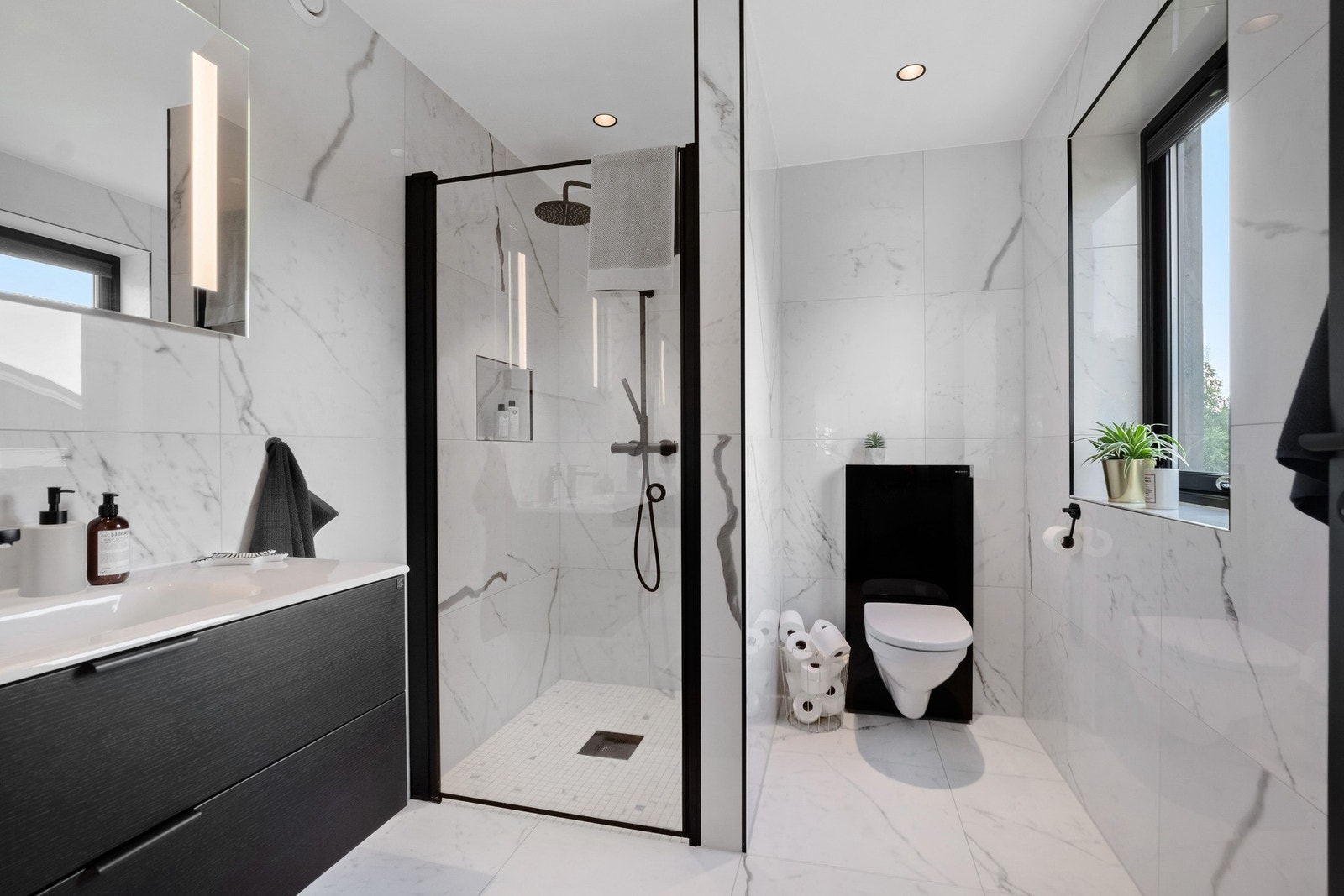 Badet tilhørende hovedsoverommet byr på en følelse av luksus med store marmorflis, regndusj, og innredning fra Drømmekjøkkenet. Galleribilde
