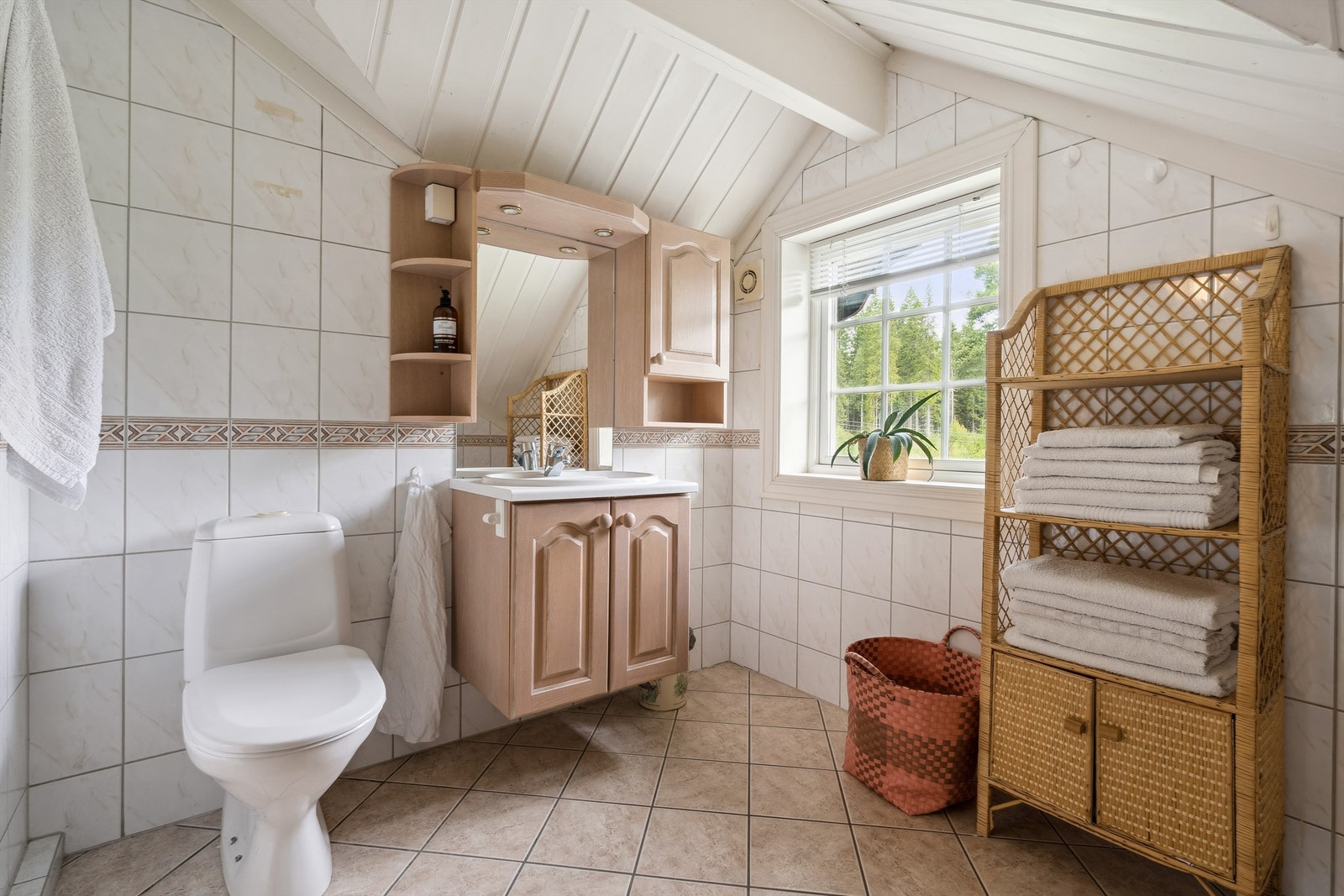 Badet i loftsetasjen har toalett, dusjvegger og nedfelt servant i innredning Galleribilde