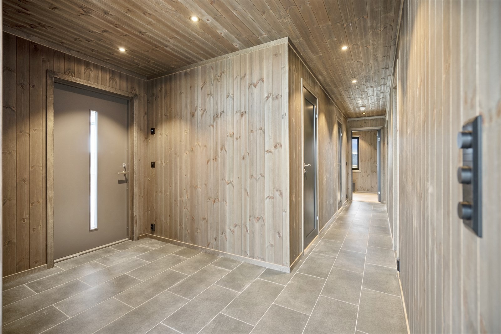 Romslig gang med mørke fliser. Galleribilde