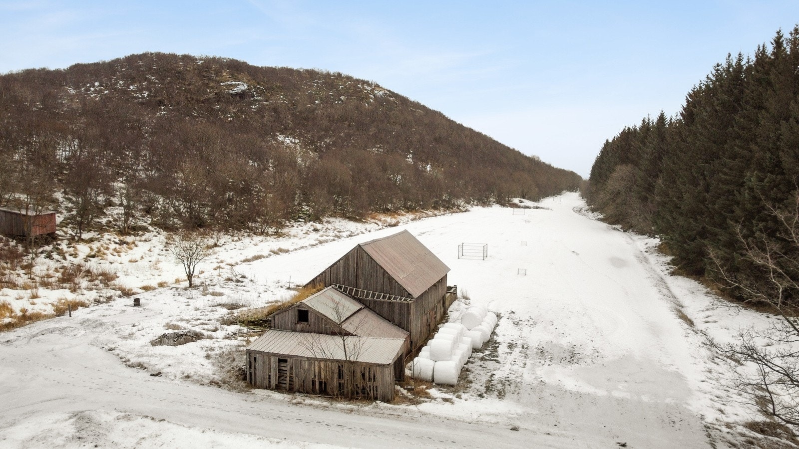 Fasade av bakside av fjøs. Her ser du en liten del av den store tomten Galleribilde