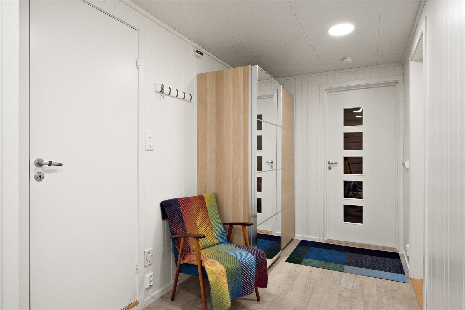 Velkommen inn. En flott dør med glassfelt leder inn til gangen som har rikelig med garderobeskap. Galleribilde