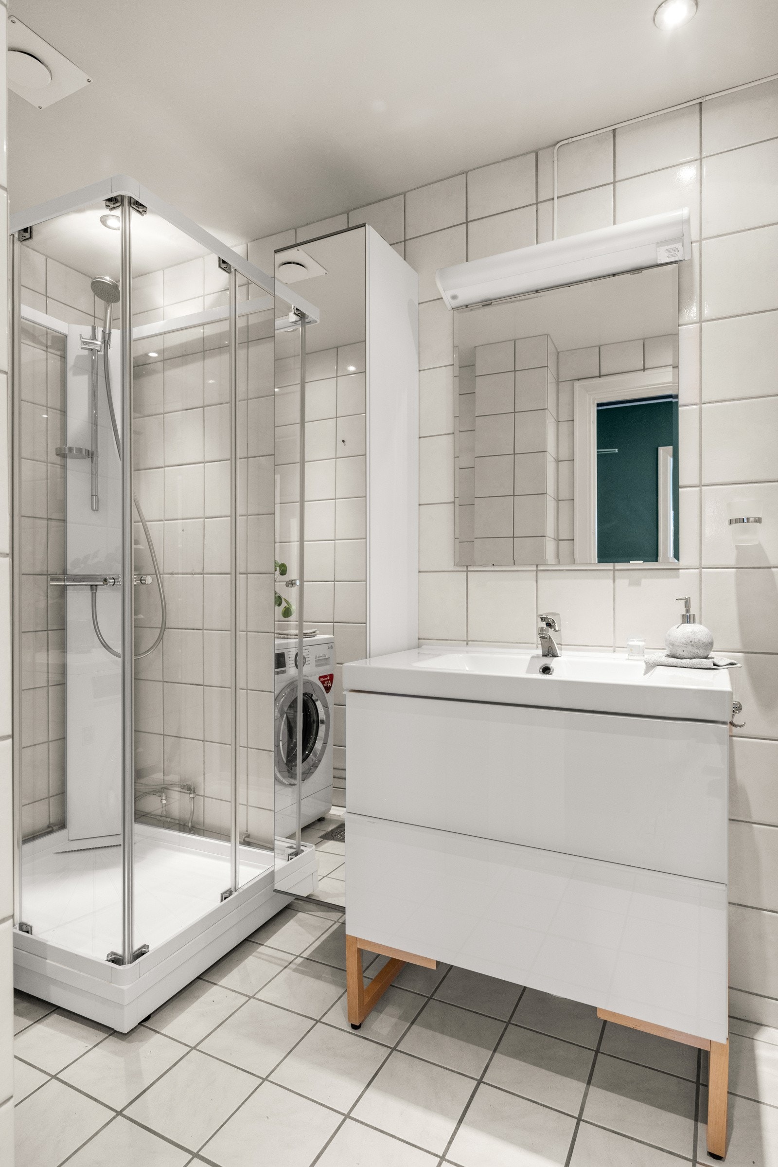 Flislagt bad med flislagt gulv med gulvvarme og senket himling med downlights. Galleribilde
