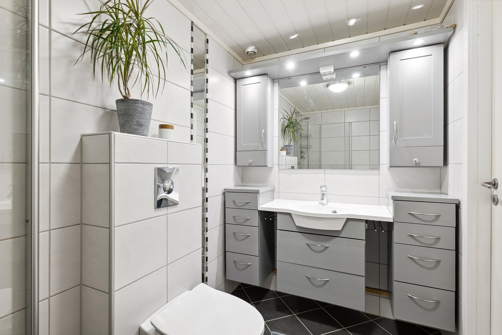 I tilknytning til hovedsoverommet i underetasjen har du et lyst og moderne baderom som ble pusset opp i 2009. Baderommet har mørke fliser på gulv med gulvvarme, hvite fliser på veggen, downlights i himlingen og ventilasjonsvifte. Galleribilde