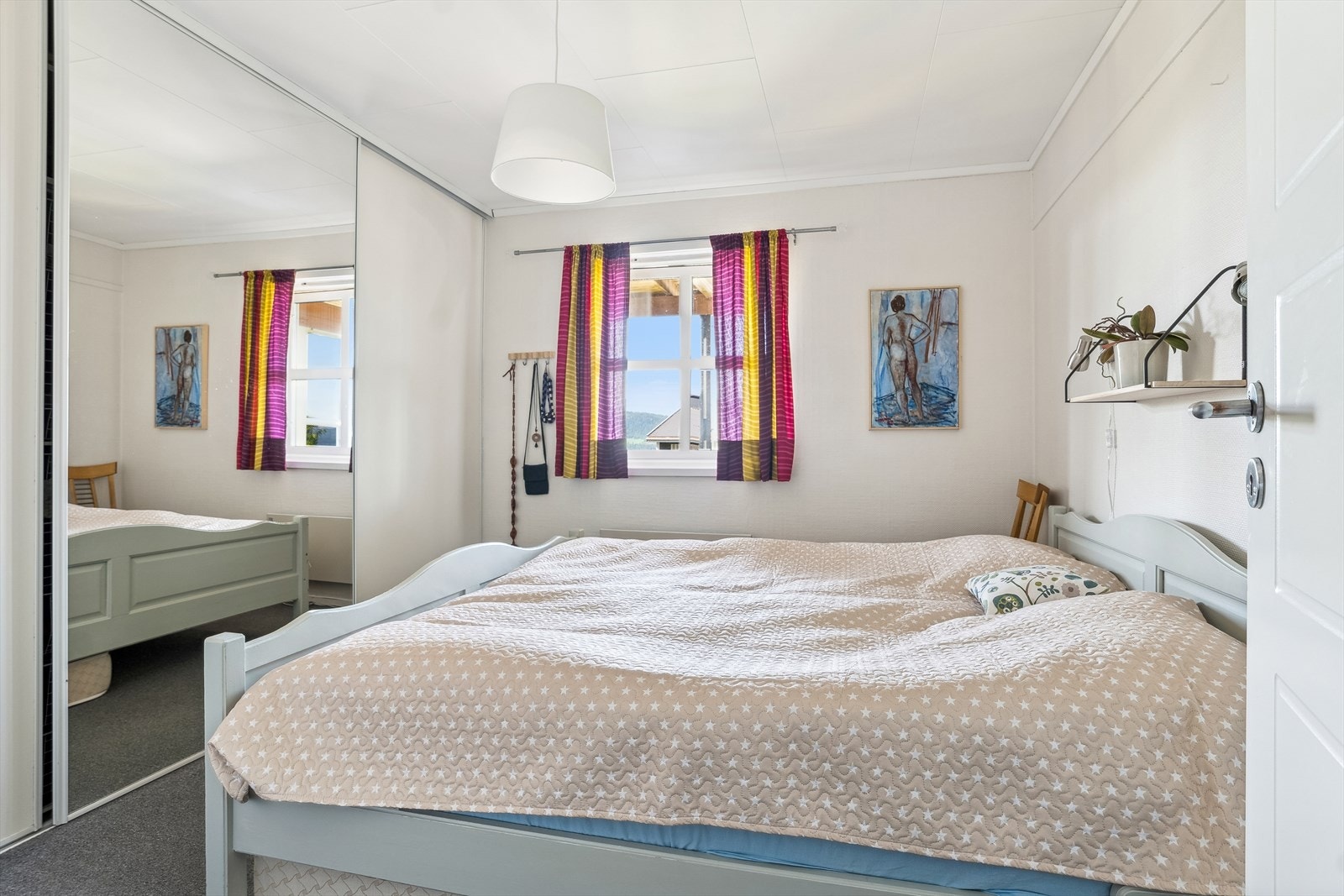 På soverommet har du god plass til en stor dobbeltseng med tilhørende nattbord, samt rikelig med oppbevaringsplass i stor plassbygget skyvedørsgarderobe. Galleribilde