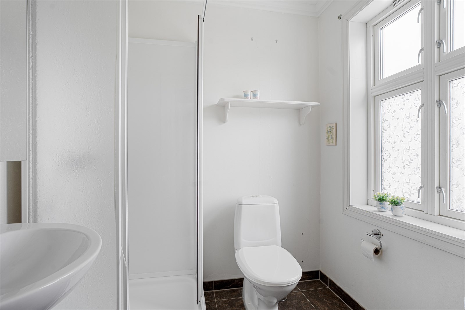 Lyst bad med fliser på gulv og malte overflater på vegger og tak Galleribilde