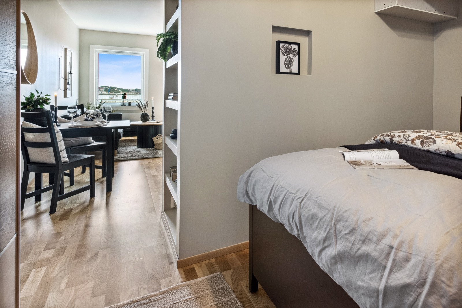 Mellom stue og alkove er det hyller i veggen som gjør at plassen utnyttes til det fulle. Hyllene kan brukes til både oppbevaring og interiør. Galleribilde