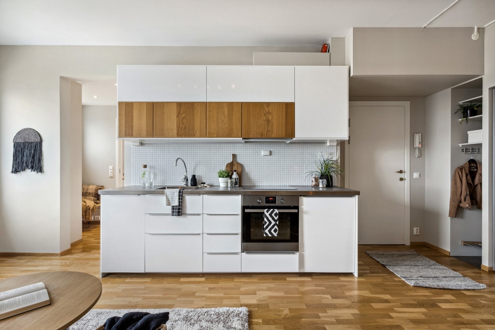 Lekkert og moderne kjøkken med glatte fronter og flis på vegg. Galleribilde