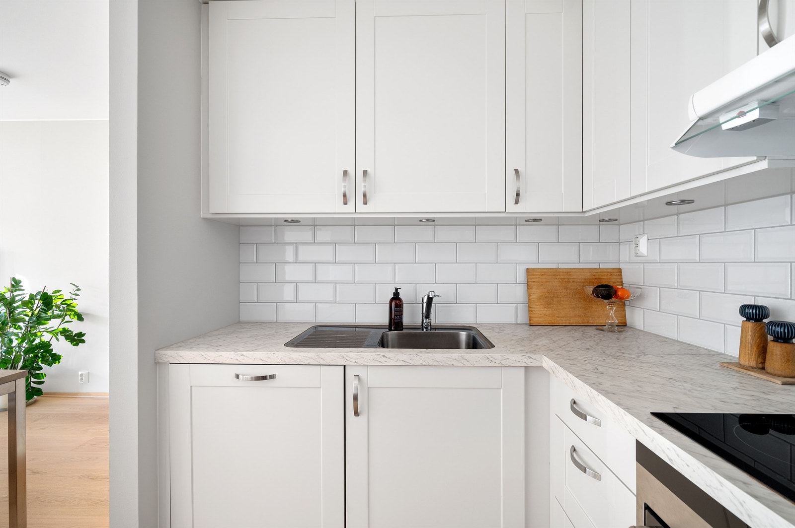 Tidløse, profilerte fronter i hvitt med lettstelt benkeplate i laminat med marmorfinish. Galleribilde