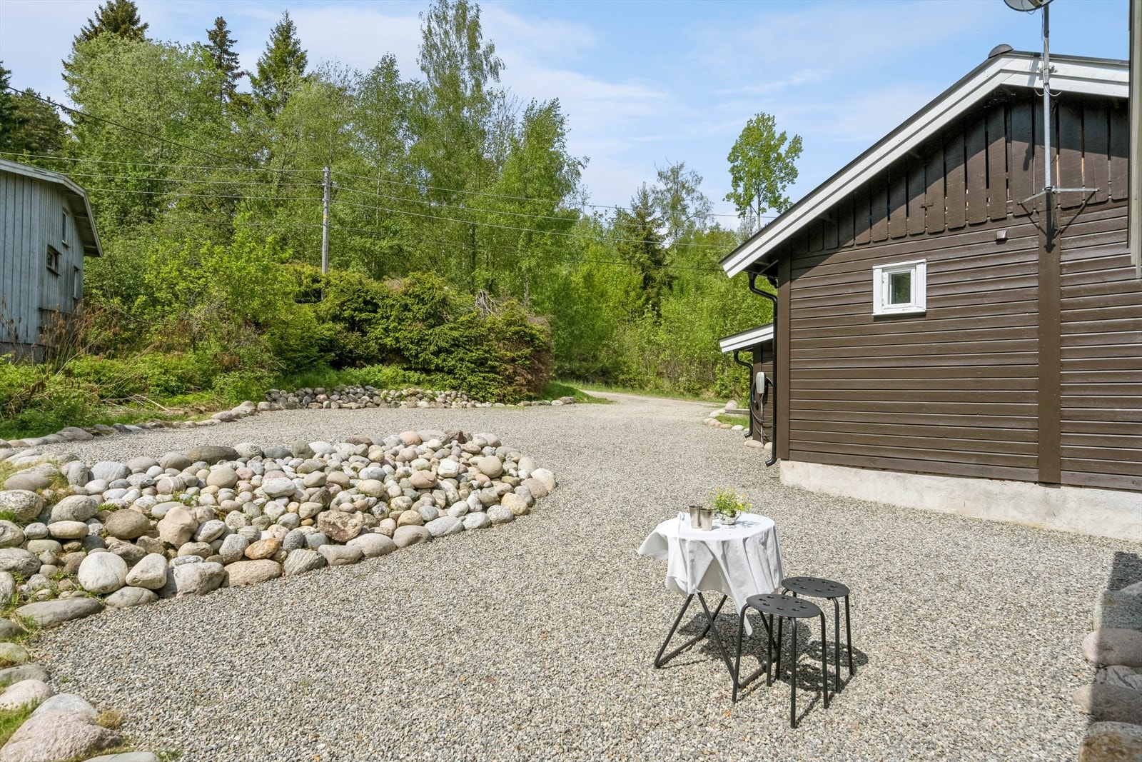 Flere plasser i solen rundt hytta. Det er også montert elbil-lader i veggen Galleribilde