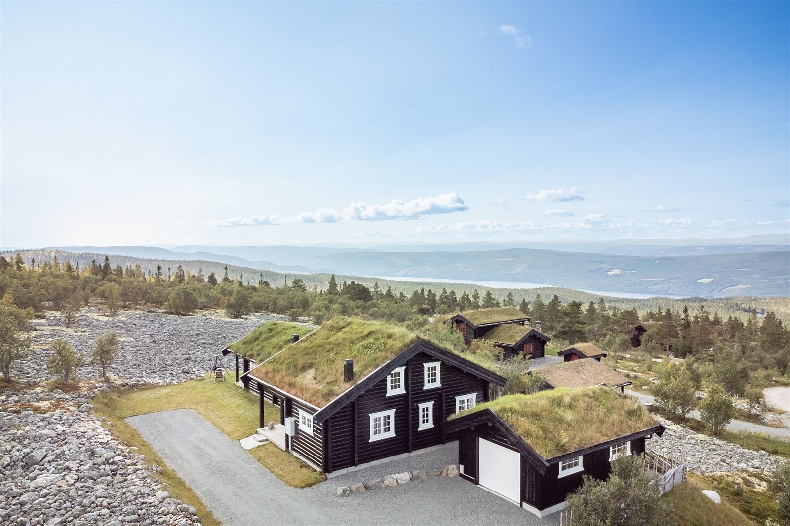 Gruset innkjøring og parkering. Eiendommen er også bebygd med en garasje på 28m² fra 2018. Det er montert ladeboks for elbil i garasjen. Galleribilde