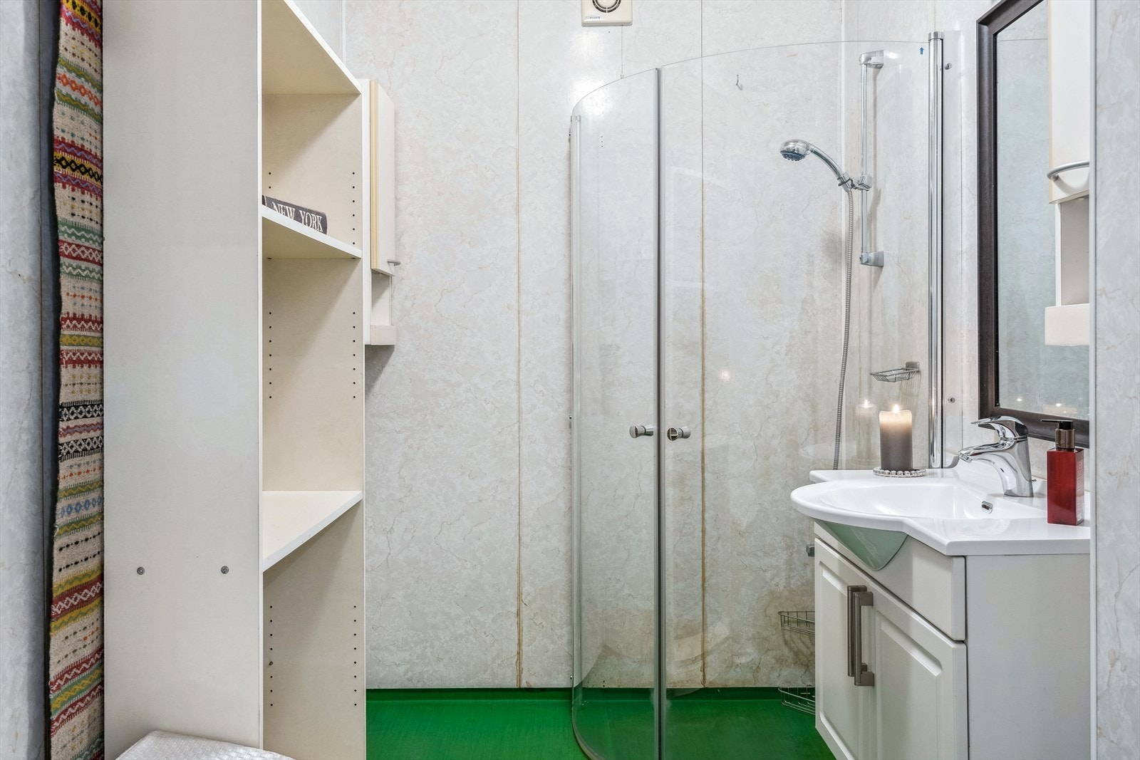 Badet består av gulvbelegg og plater på vegger. Innredet med gulvmontert toalett, servant i innredning og dusjhjørne med vegger. Galleribilde