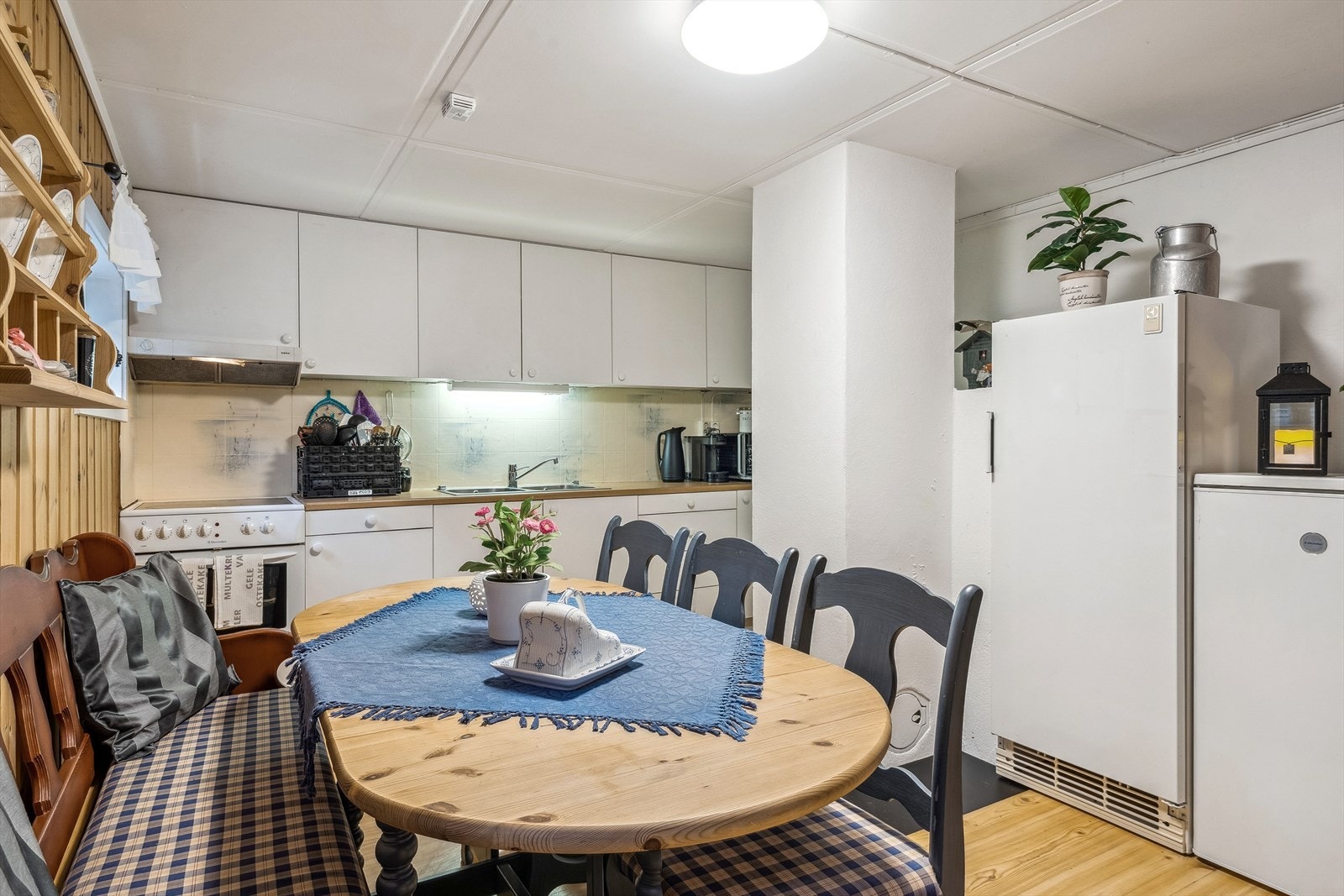 Det er god størrelse på kjøkkenet i kjelleren, med plass til spisebord/kjøkkenbord. Her er det nyere innredning med god skapplass. Frittstående komfyr, kjøleskap og frys. Galleribilde