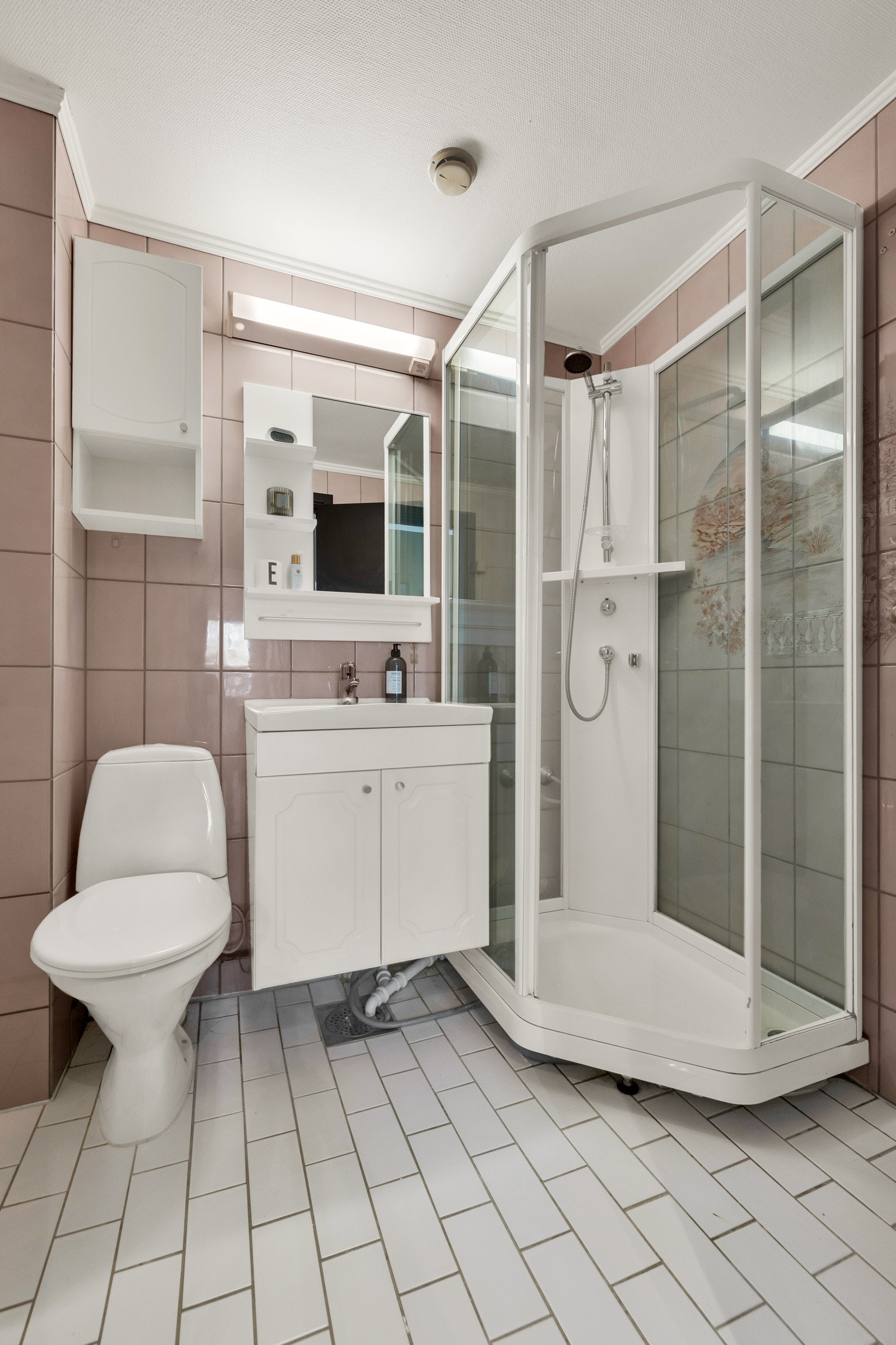 Leiligheten har et litt eldre, flislagt bad Galleribilde