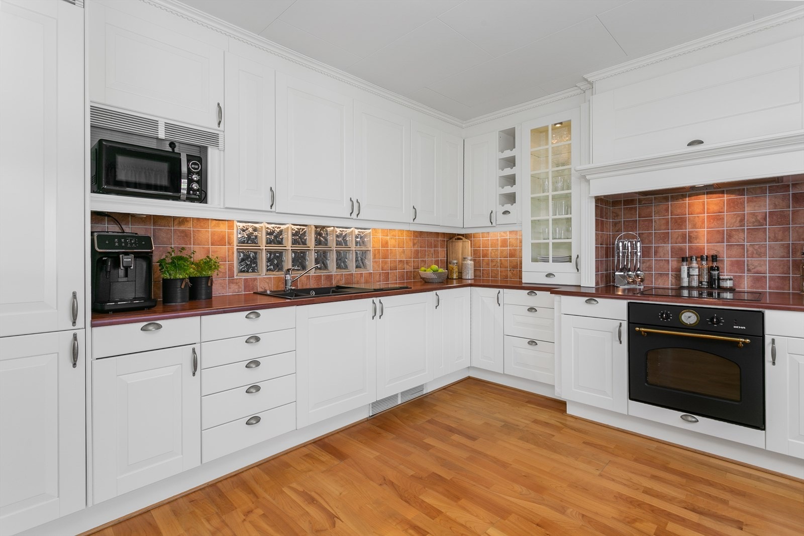 Over kjøkkenbenken er det fliser i farge som matcher benkeplata Galleribilde