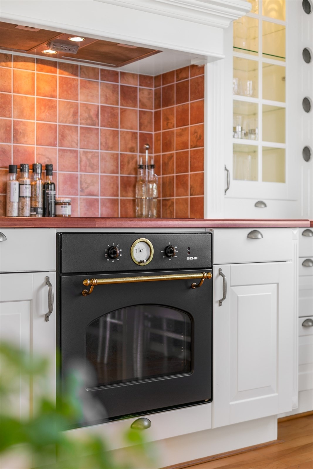 På hver side av kjøkkengrua er det et dekorativt benkevitrine med belysning Galleribilde