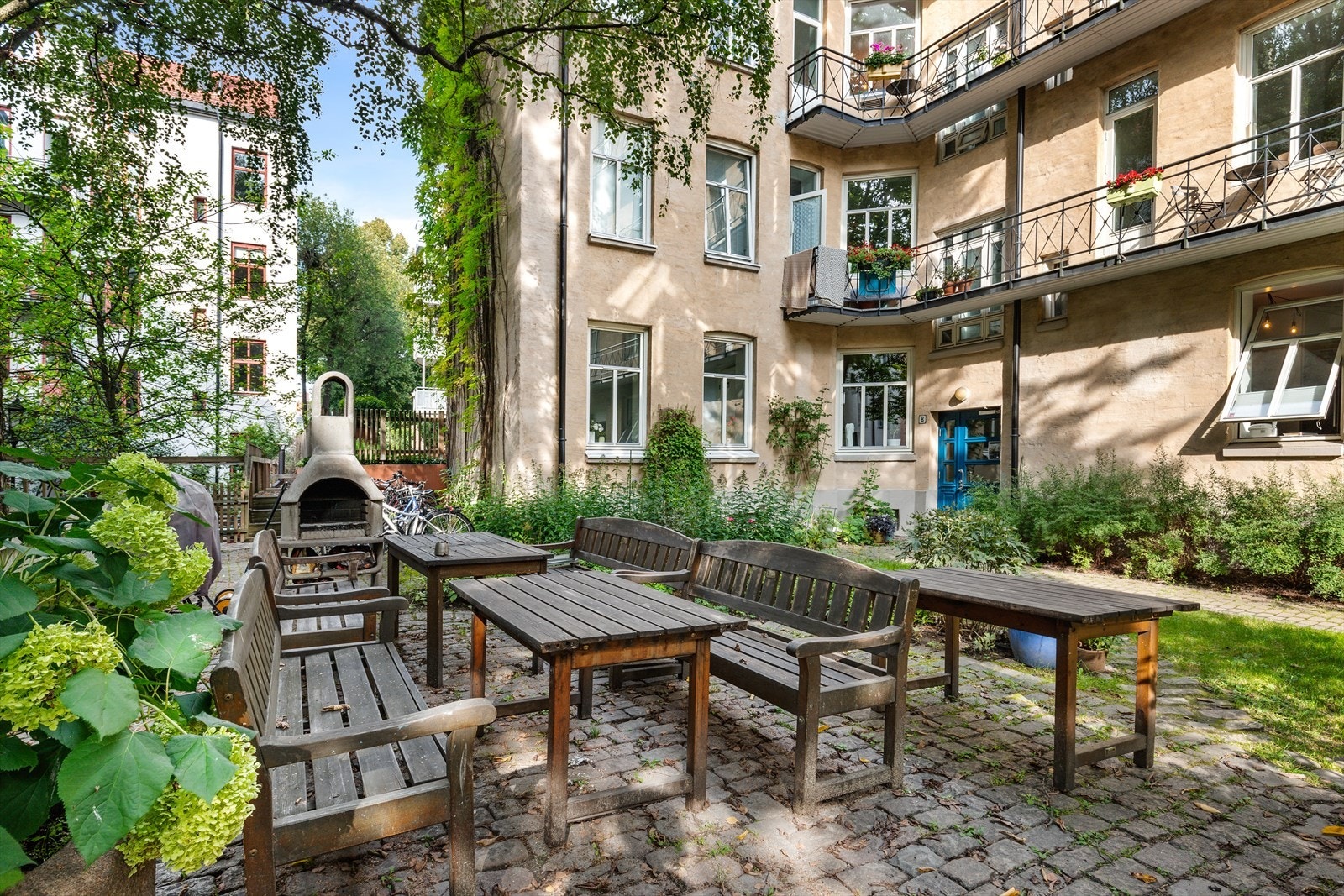 Idyllisk og koselig fellesområde med sittegrupper og utepeis. Galleribilde