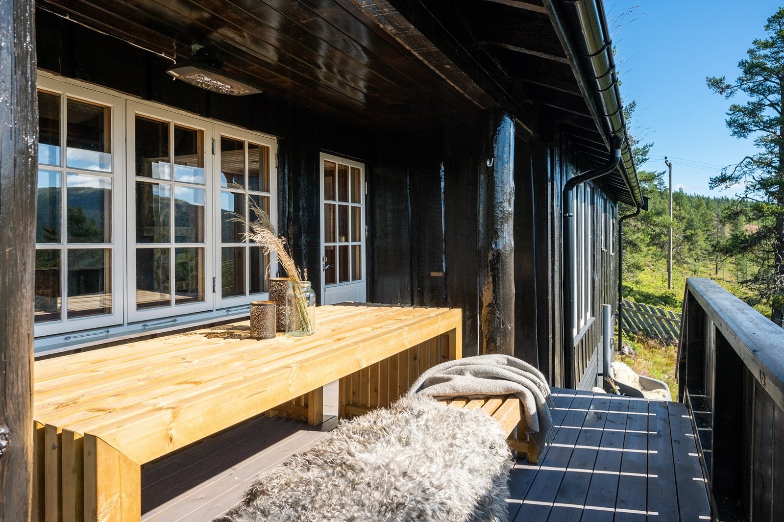 Solrik terrasse som strekker seg rundt store deler av hytta. Galleribilde
