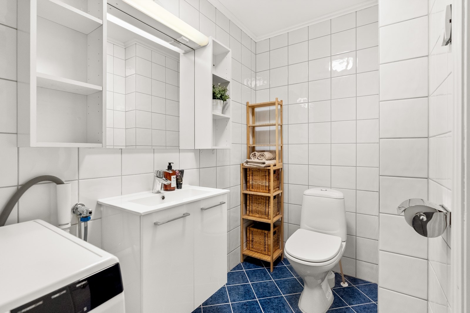 Badet er flislagt med gulvvarme og har servantinnredning med skap, speil og belysning. Galleribilde