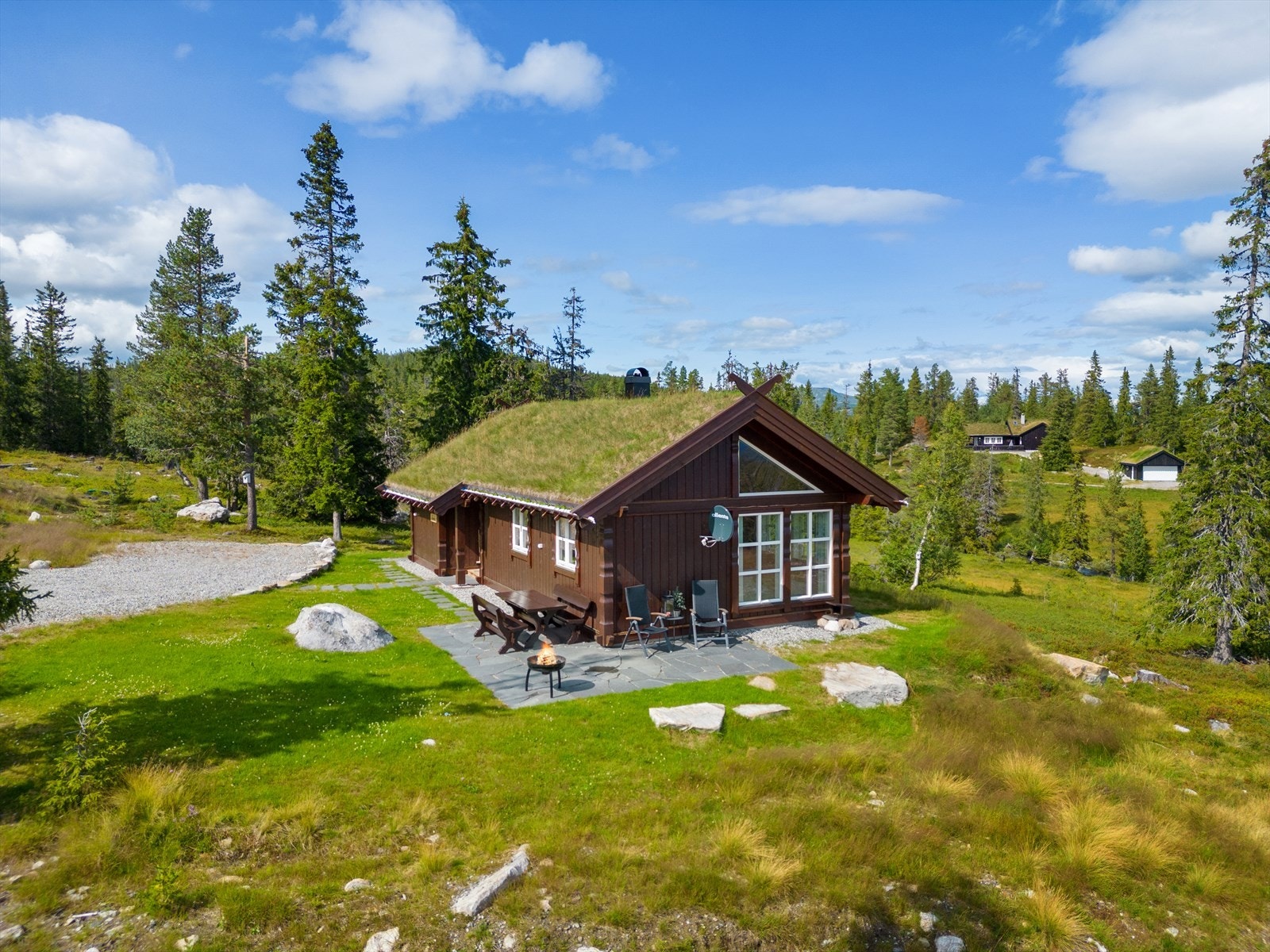 Pent opparbeidet uteområde med gruset innkjørsel og plenareal. Resten naturtomt. Galleribilde
