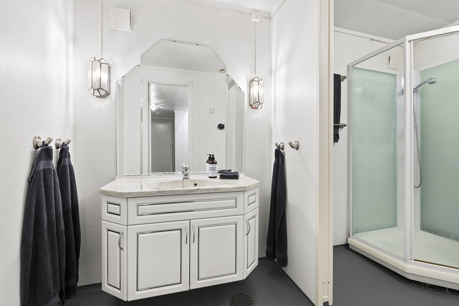 Badet er av eldre dato og inneholder håndvask med skap, dusjkabinett og opplegg for vaskemaskin. Gulvet er nylig malt! Galleribilde