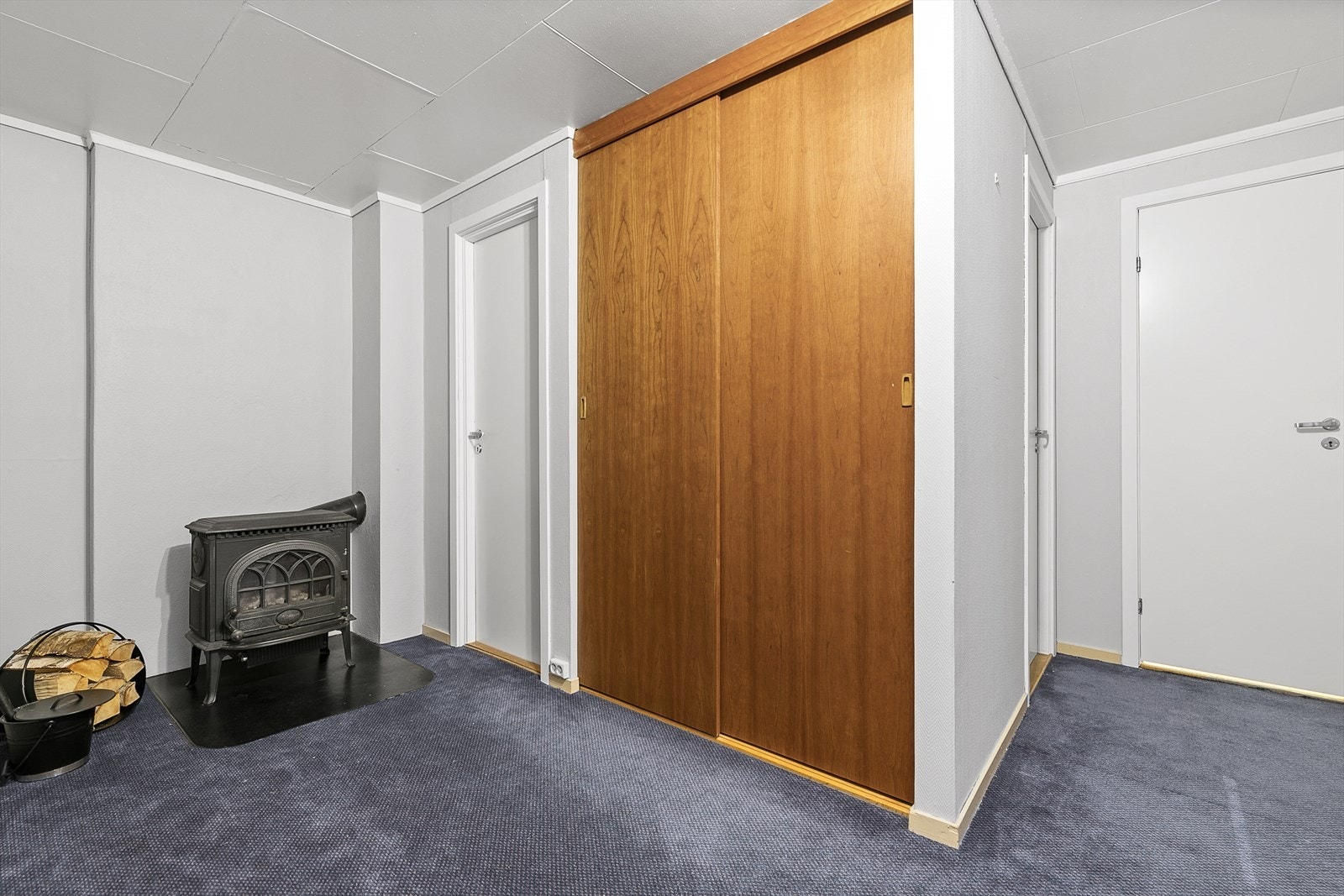Gang med vedovn, skyvedørsgarderobe og inngang til boder og resten av rommene i underetasjen. Galleribilde