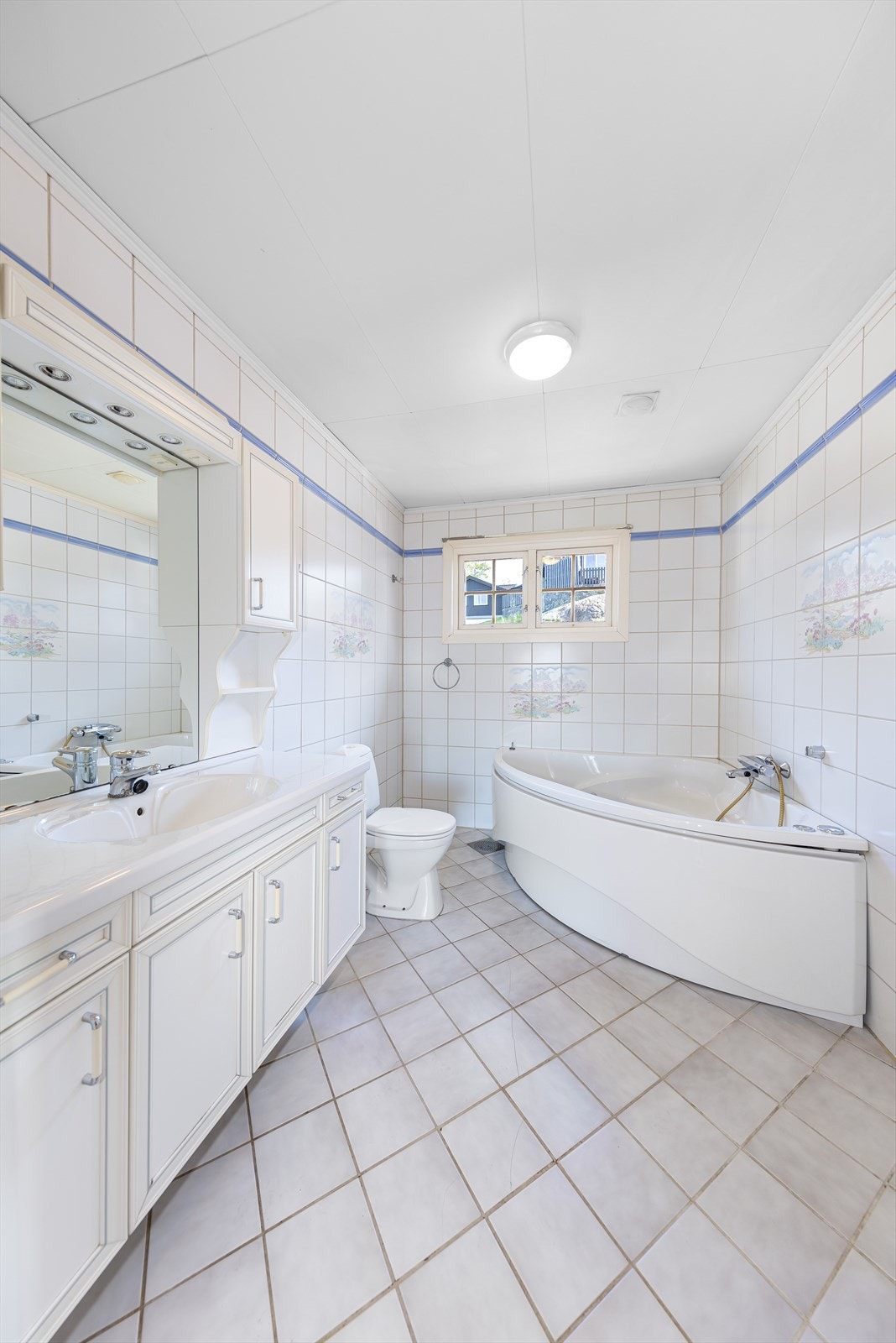 Badet er flislagt og inneholder badekar, wc, servant med skap og opplegg til vaskemaskin. Galleribilde