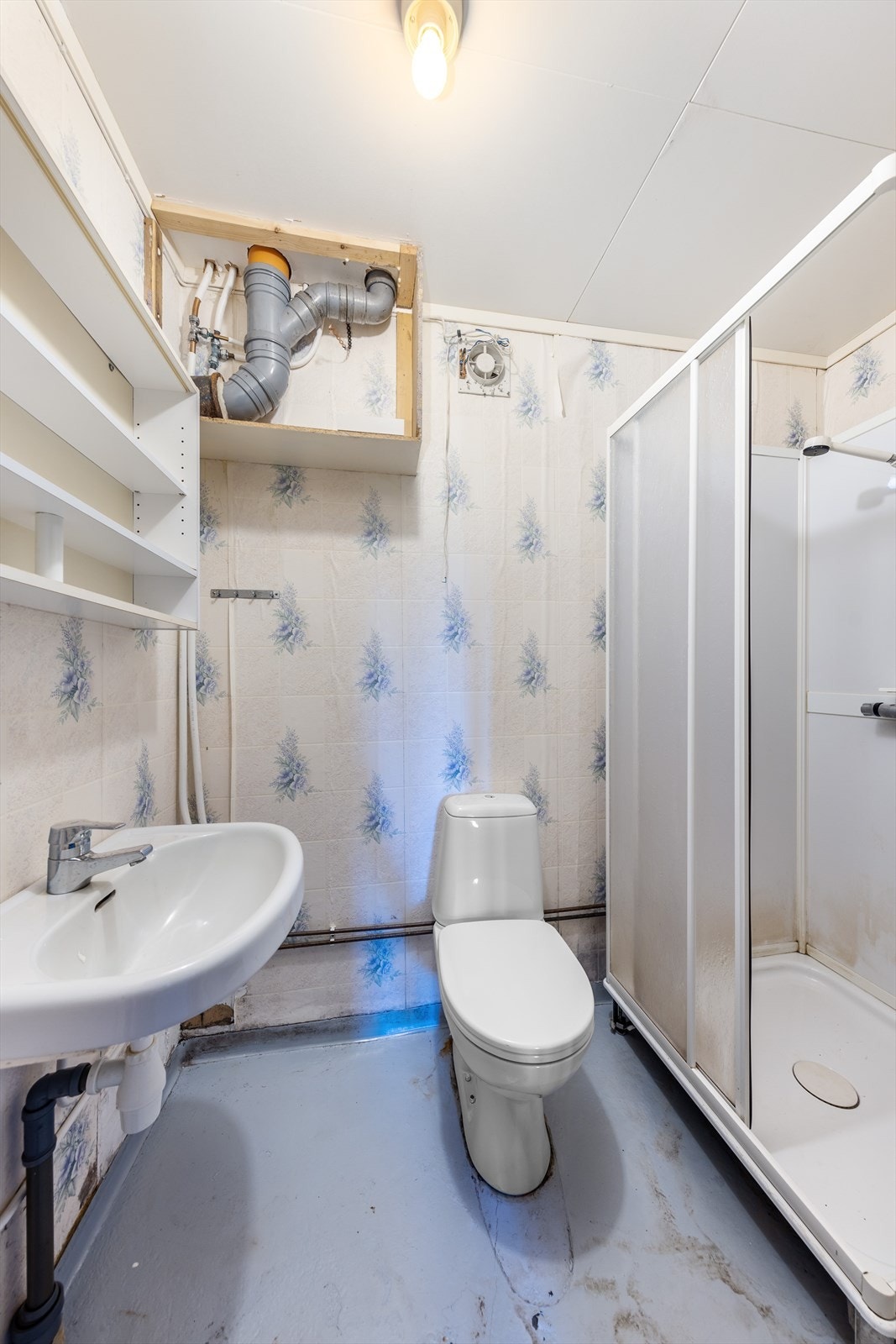Når du går ned via innvendig trapp kommer du først til en mellomgang og et eldre bad (ikke omsøkt). Badet har dusjkabinett, wc og servant. Galleribilde