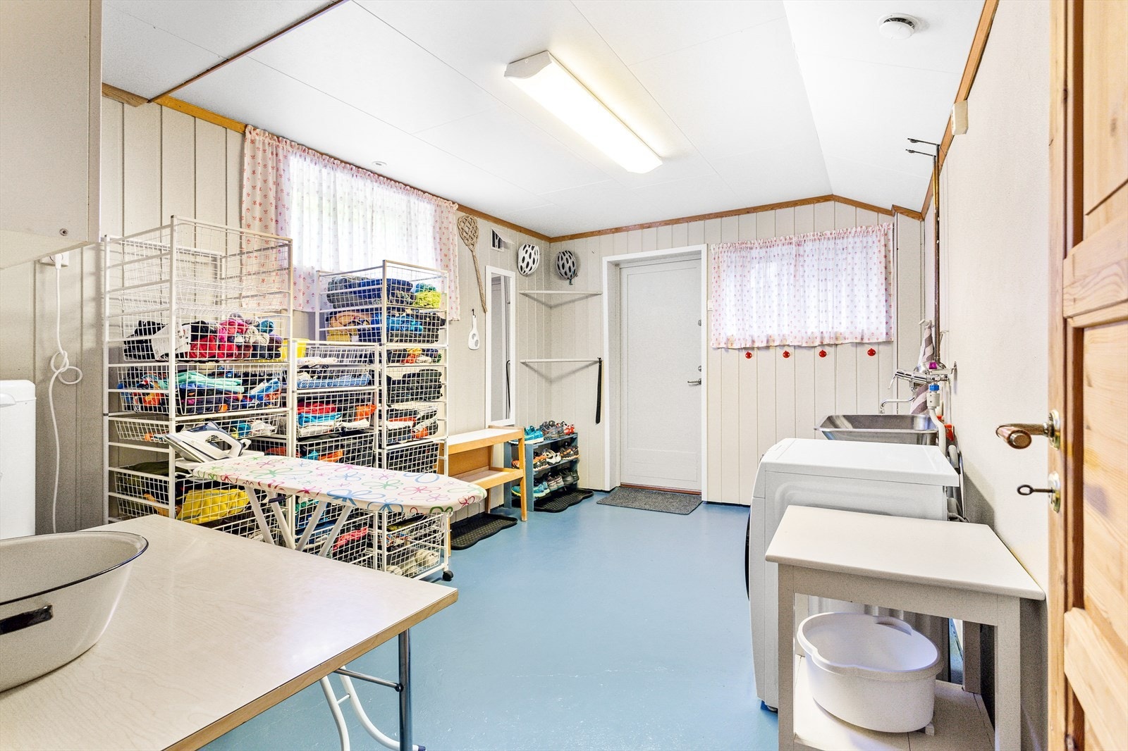 Vaskerom med egen praktisk inngang. Rommet har malte murvegger og panel på vegger. Enkel innredning med skaper og benk. Opplegg for vaskemaskin. Galleribilde