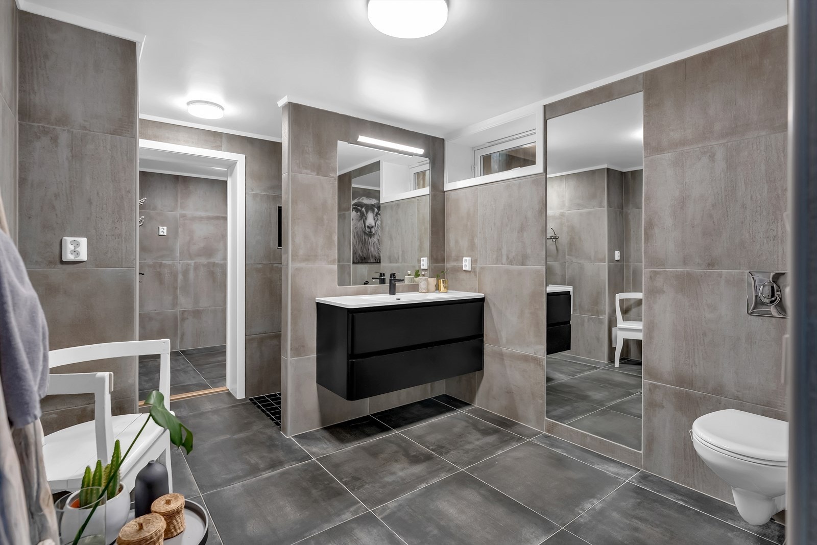 Boligens andre baderom ligger innerst i første etasje. Badet er flislagt med varme i gulv, toalett, baderomsinnredning og dusjnisje. Galleribilde