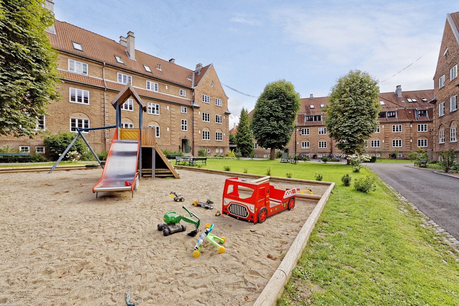 Tomten er pent opparbeidet med asfalterte og brosteinsbelagte internveier. Variert beplantning, lekeplass og sittegrupper. Galleribilde