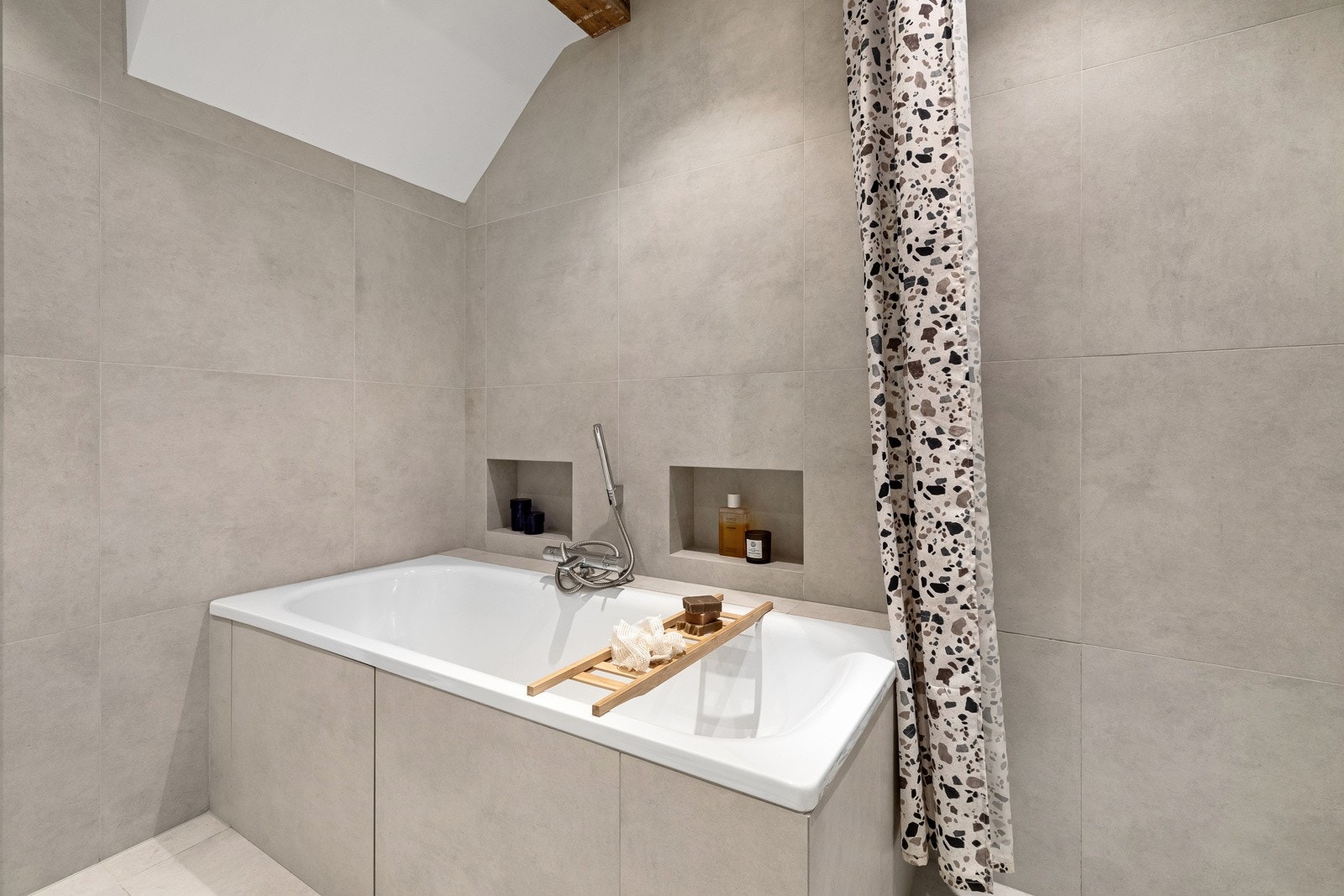 Videre inneholder baderommet et innebygd badekar med hånddusj. Galleribilde