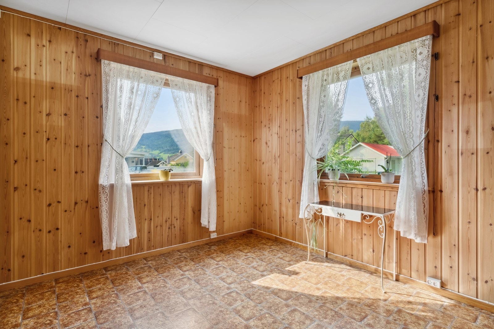 Stue har belegg på gulv og panel på vegg. Galleribilde