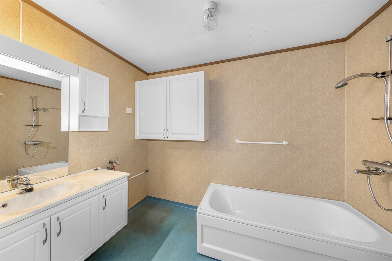 Badet er eldre og moden for renovering. Rommet har belegg på gulv og tapet på vegger. Galleribilde