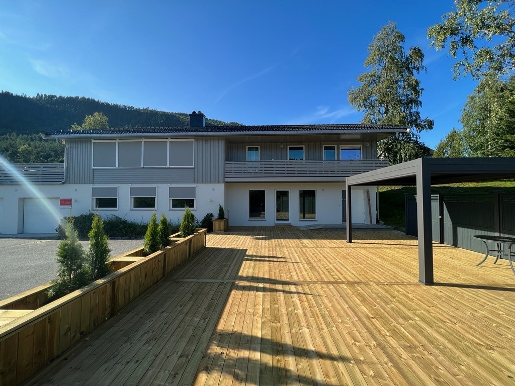 Fasade - det er etablert en stor platting med pergola utenfor inngangspartiet Galleribilde